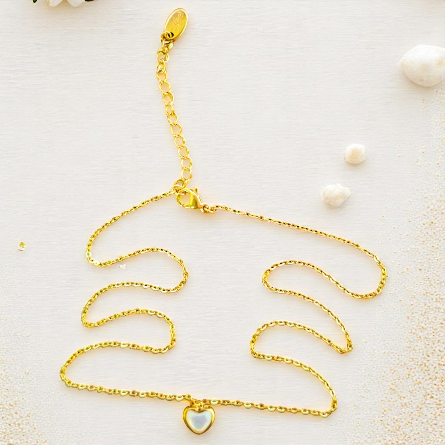 Set de collar dorado con dije de corazón de nácar y aretes de estrella