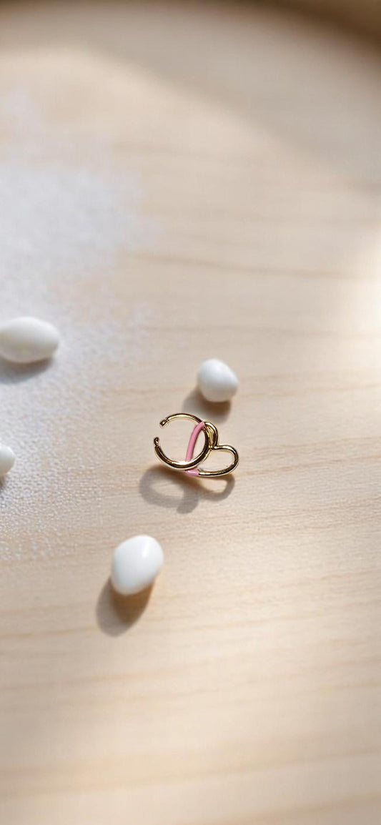Earcuff con corazón rosa sobre cuaderno cuadriculado