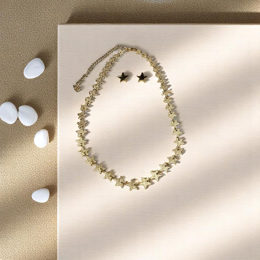 Collar dorado con estrellas brillantes junto a piedras blancas decorativas