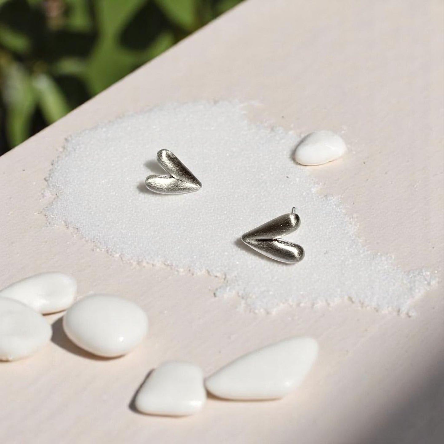Aretes corazón plateado Nova con fondo de playa