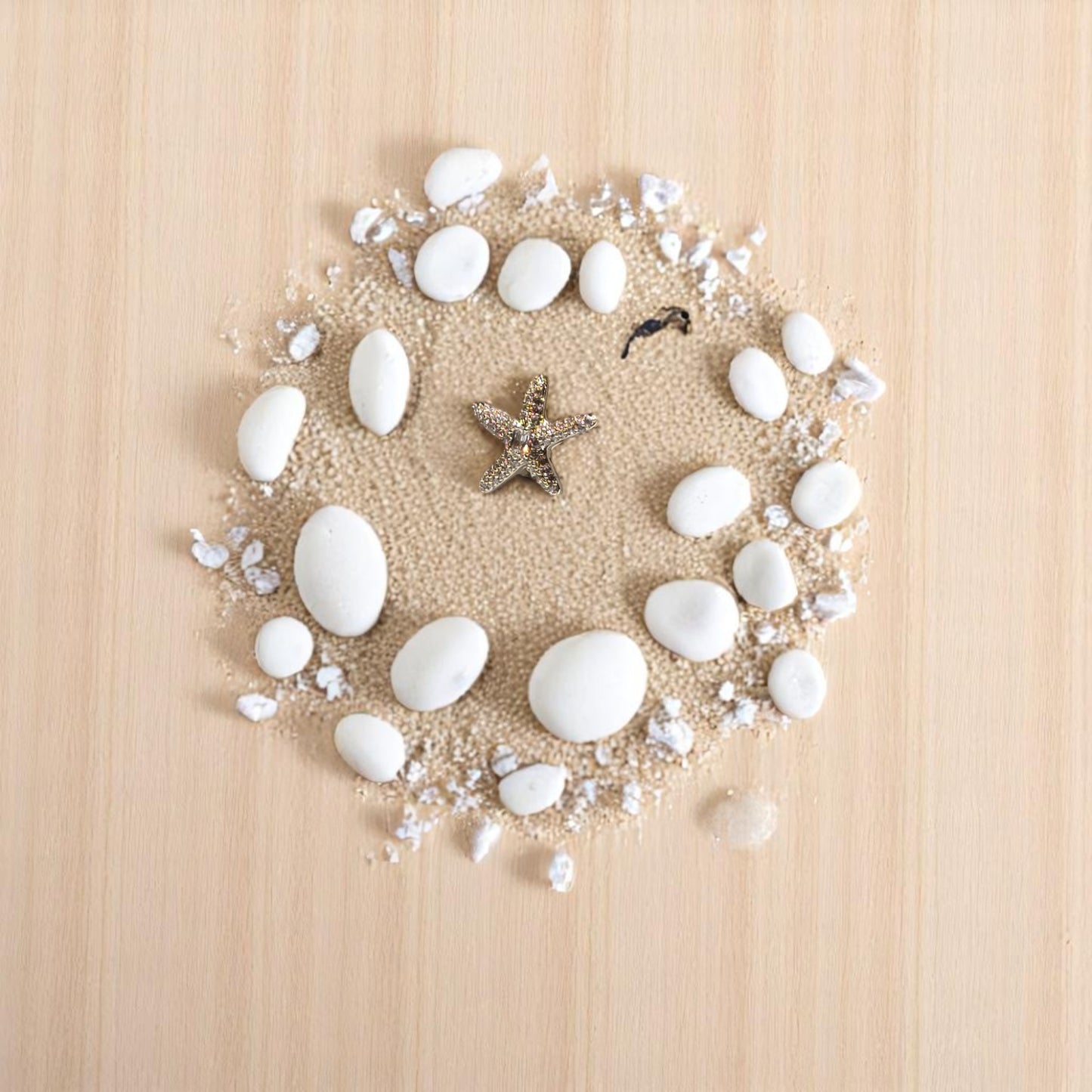 Vista cercana de earcuff estrella de mar proyectando sombra en la arena