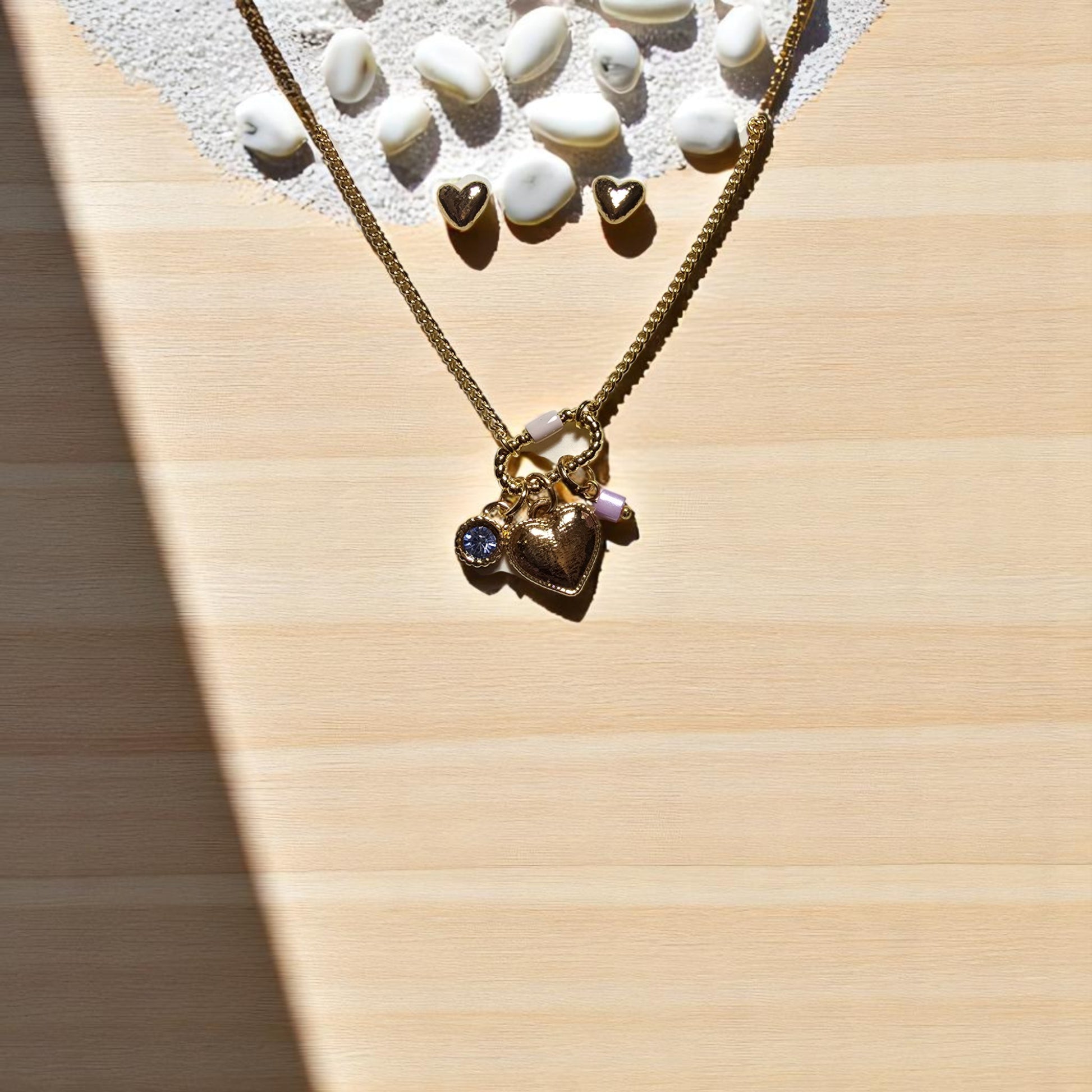 Detalle de broche con charms y cadena bañada en oro