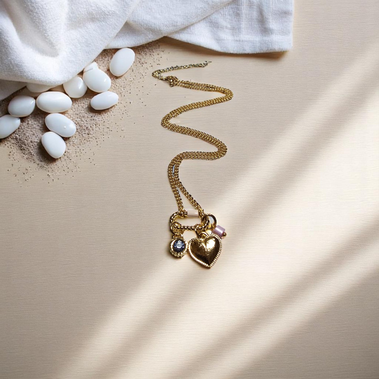 Collar en forma de corazón junto a piedras decorativas blancas