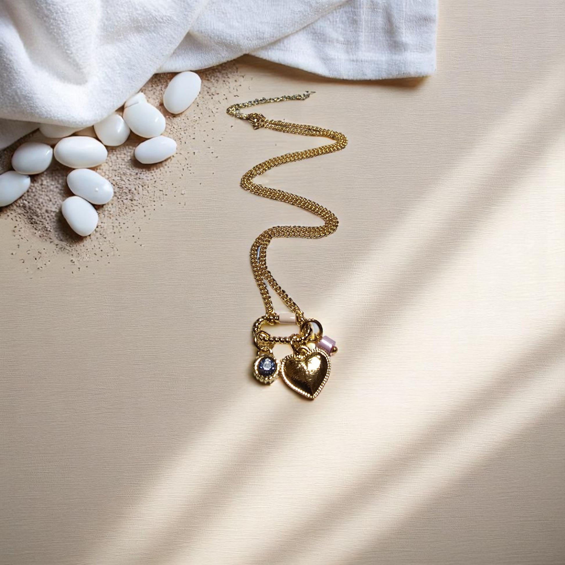 Collar en forma de corazón junto a piedras decorativas blancas