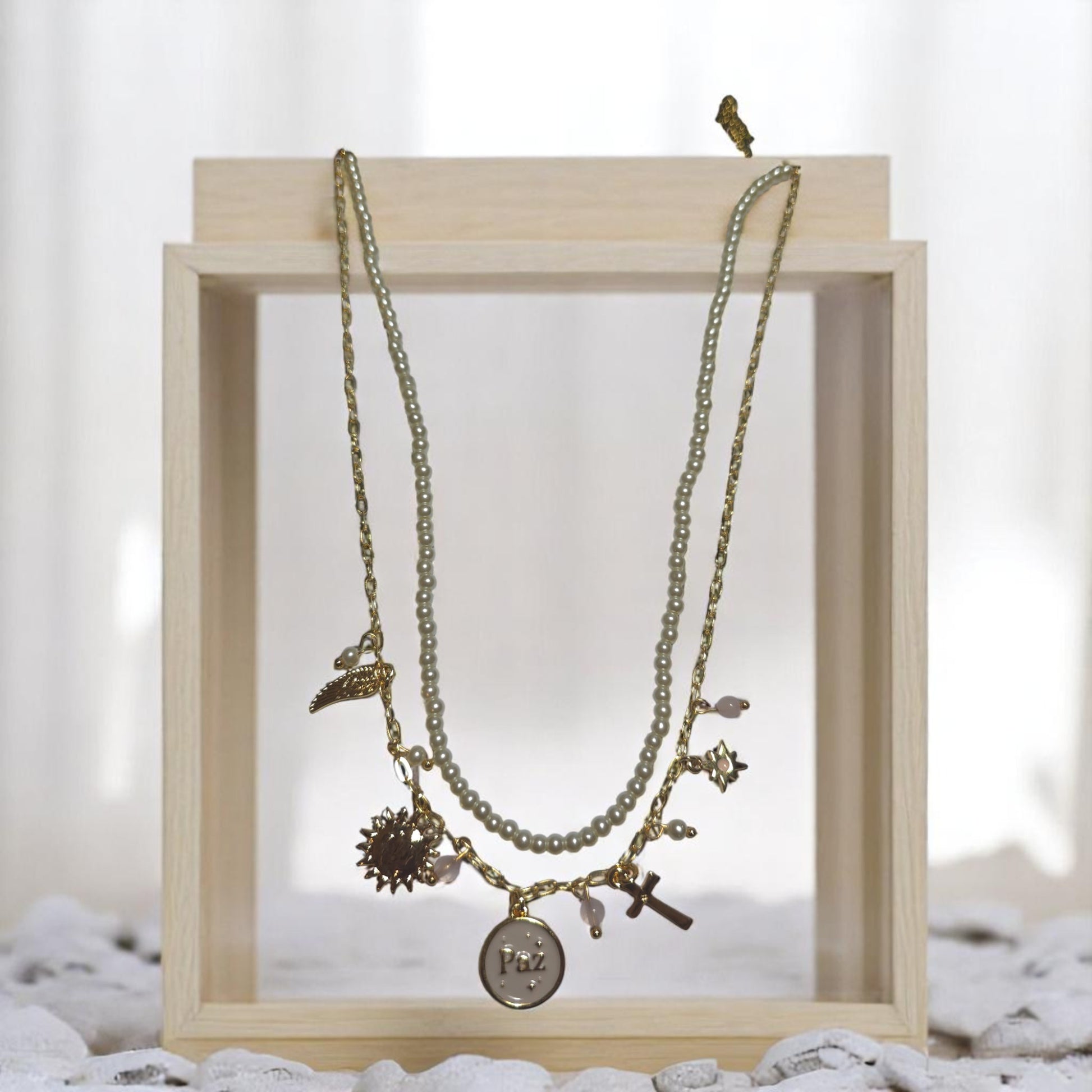 Collar dorado con perlas sintéticas y dijes de protección
