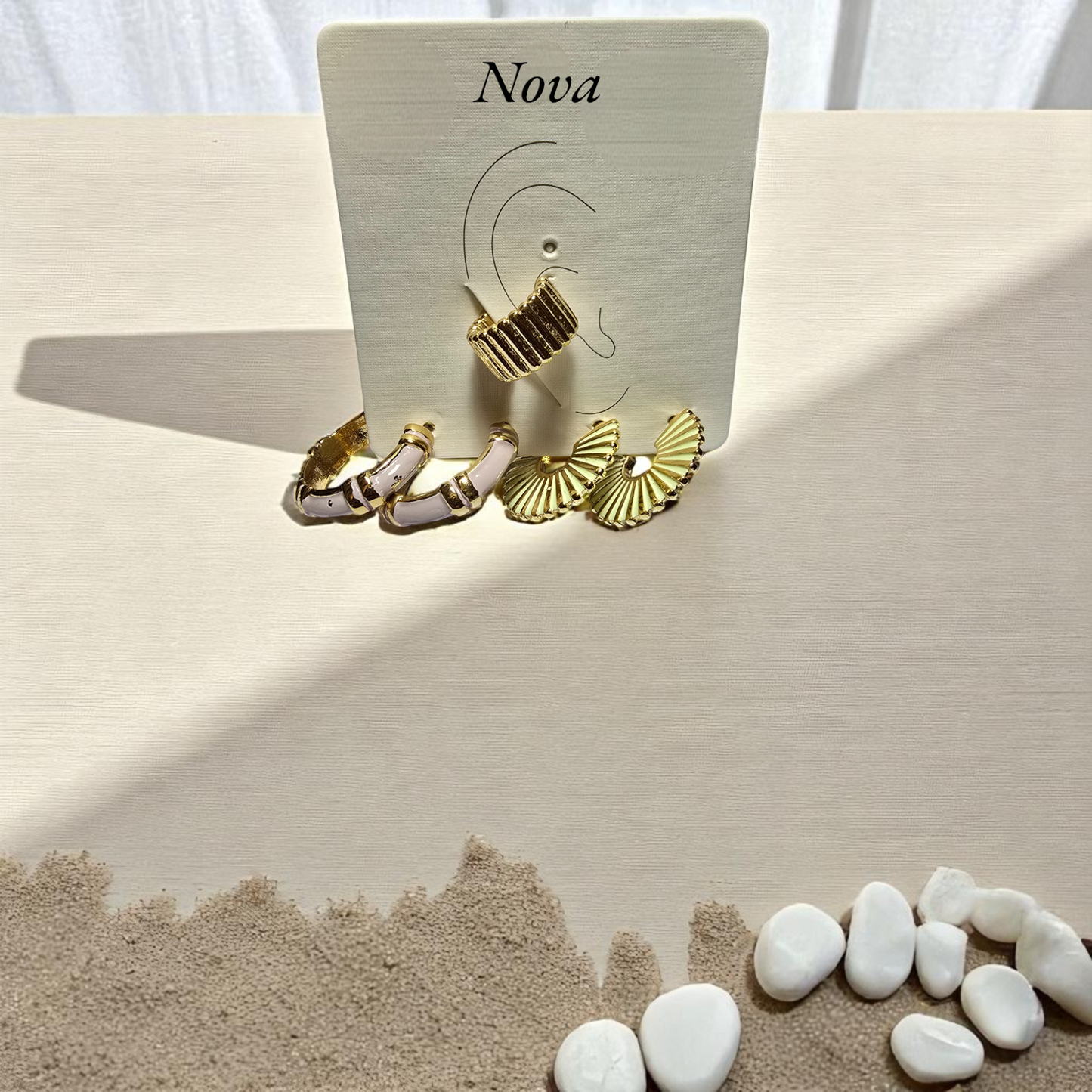 Detalle de broche con charms y cadena bañada en oro
