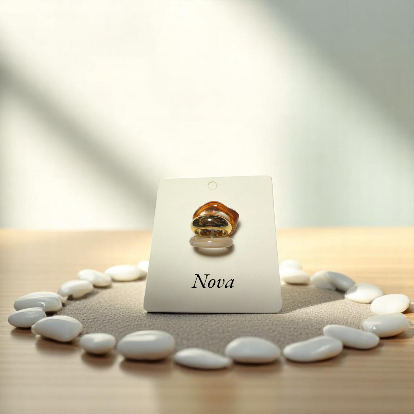 Anillos dorado, crema y caramelo en disposición vertical sobre soporte