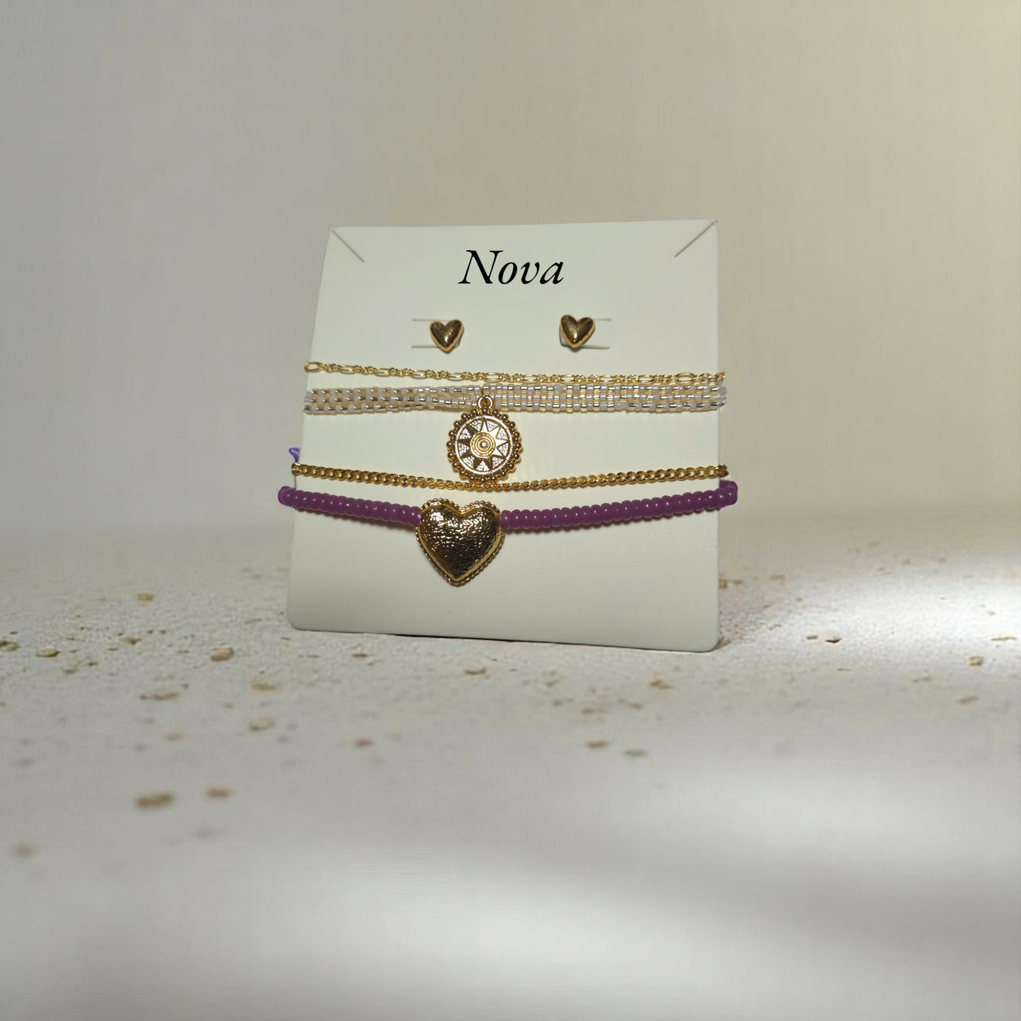 Pulsera de cadena dorada con hilo lila en fondo claro con sombras suaves