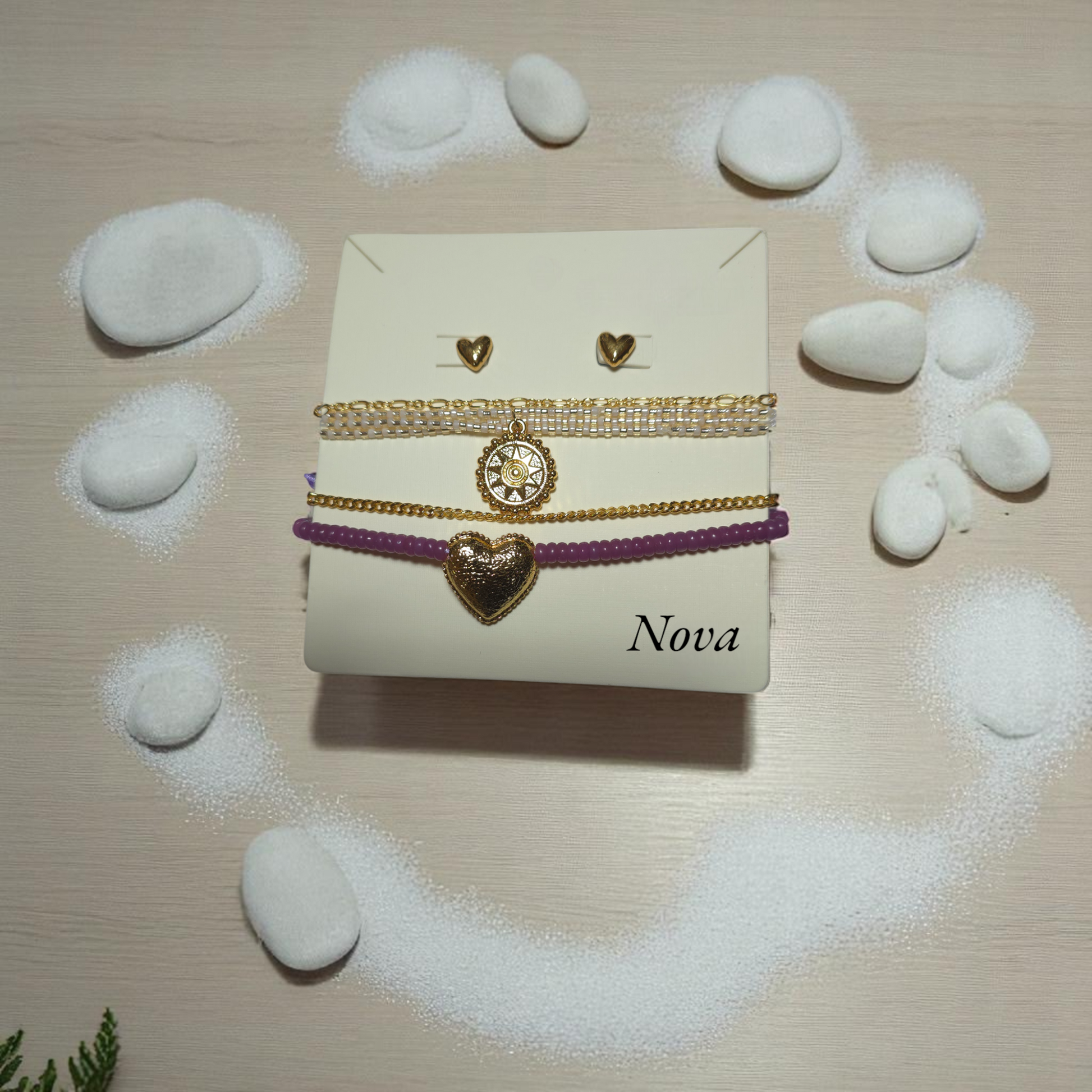 Set de cuatro pulseras doradas con aretes corazón sobre fondo neutro