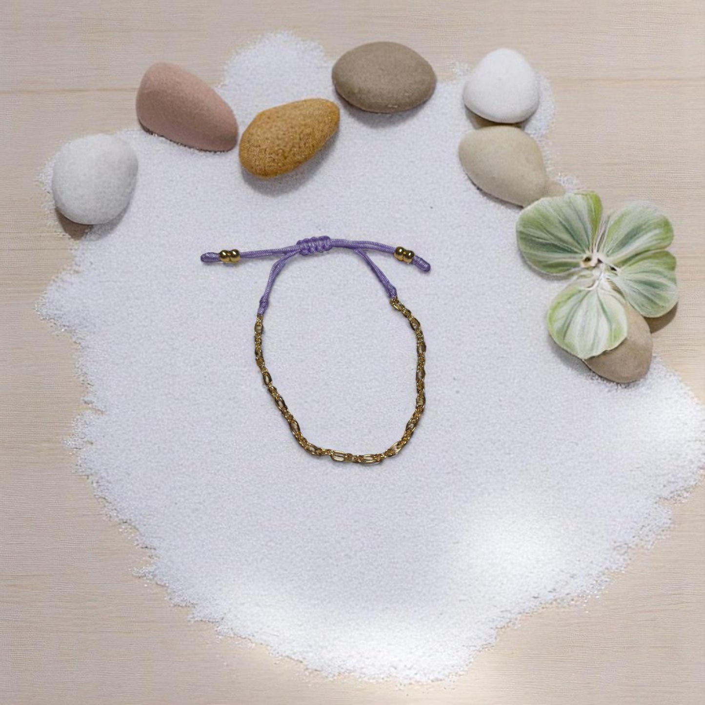 Set de cuatro pulseras doradas con aretes corazón sobre fondo neutro