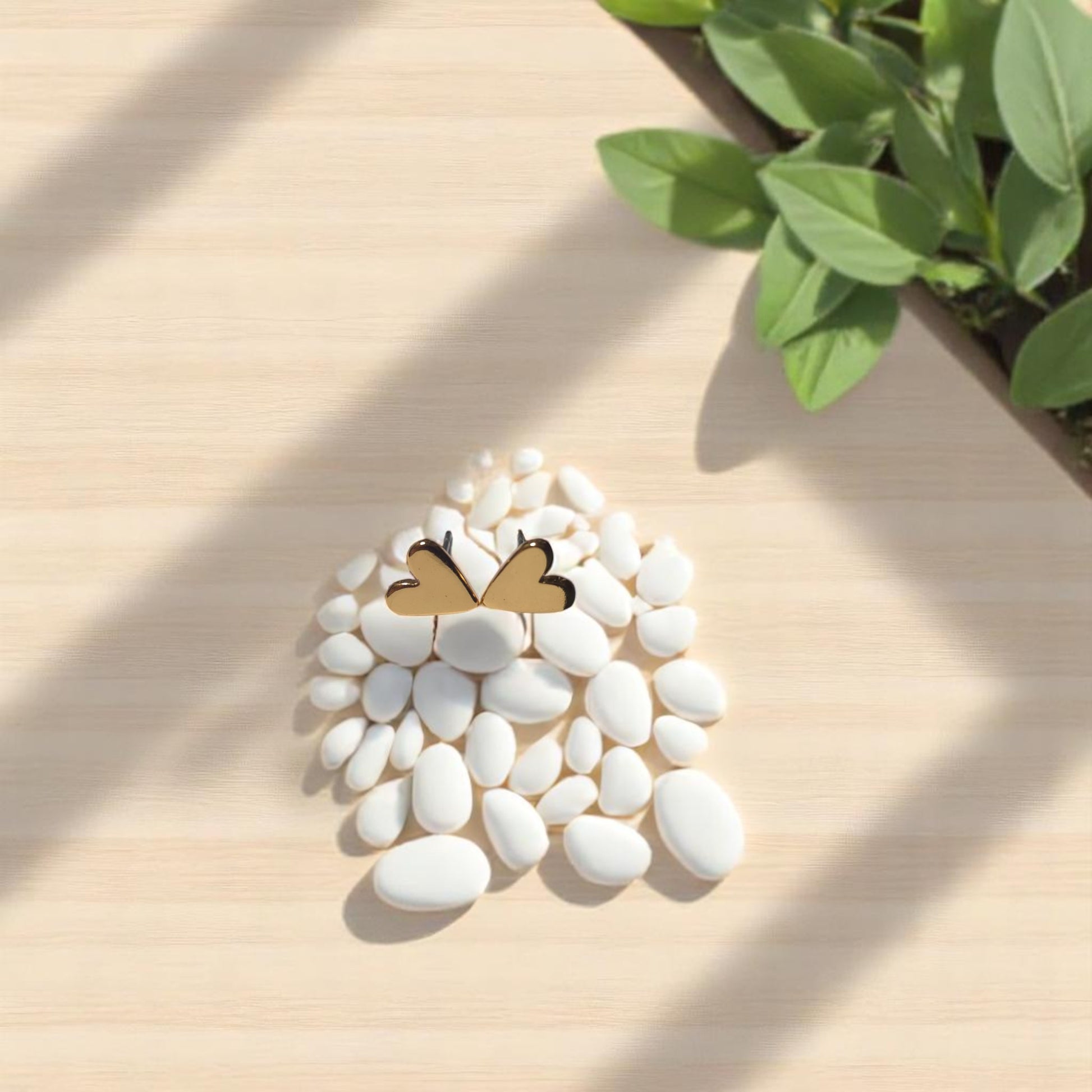 Set de collares layering dorados con dijes de corazón y aretes en fondo natural