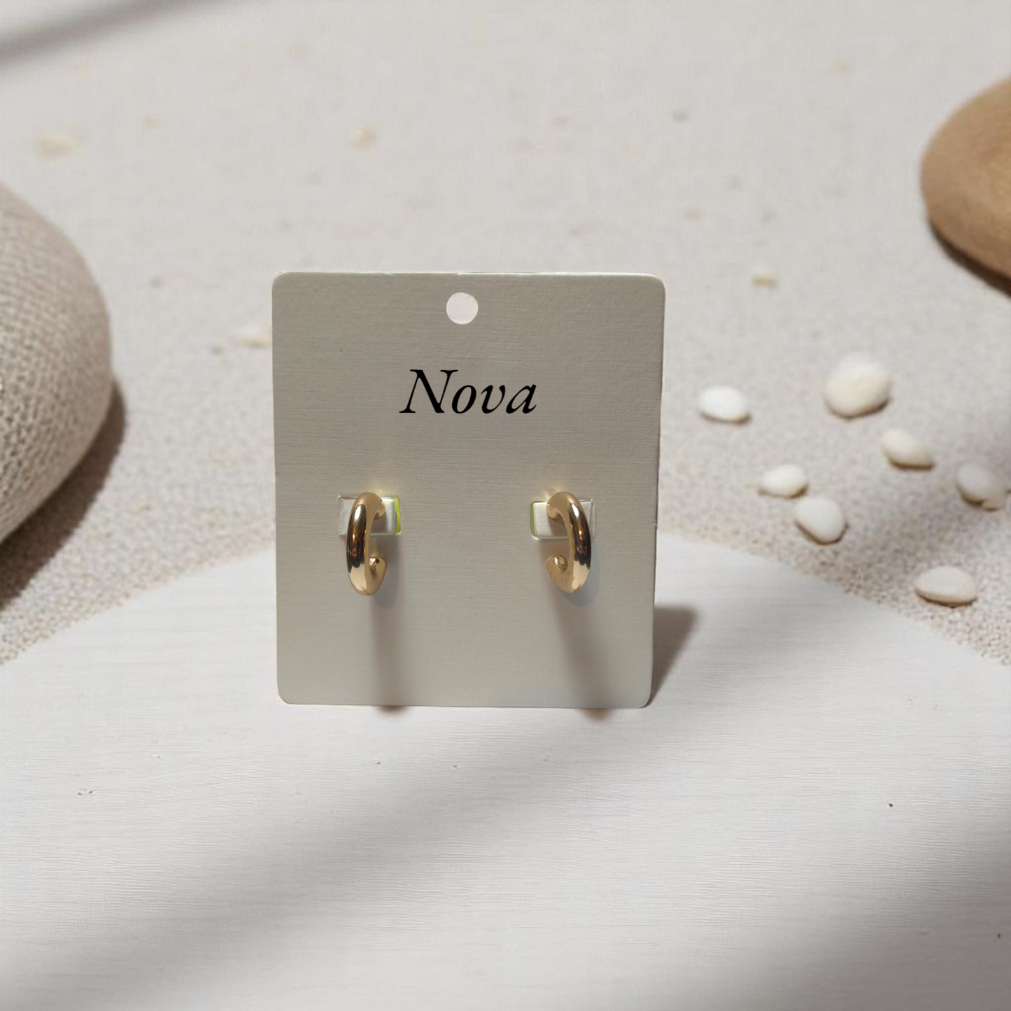 Detalle de aretes mini en dorado brillante con textura pulida