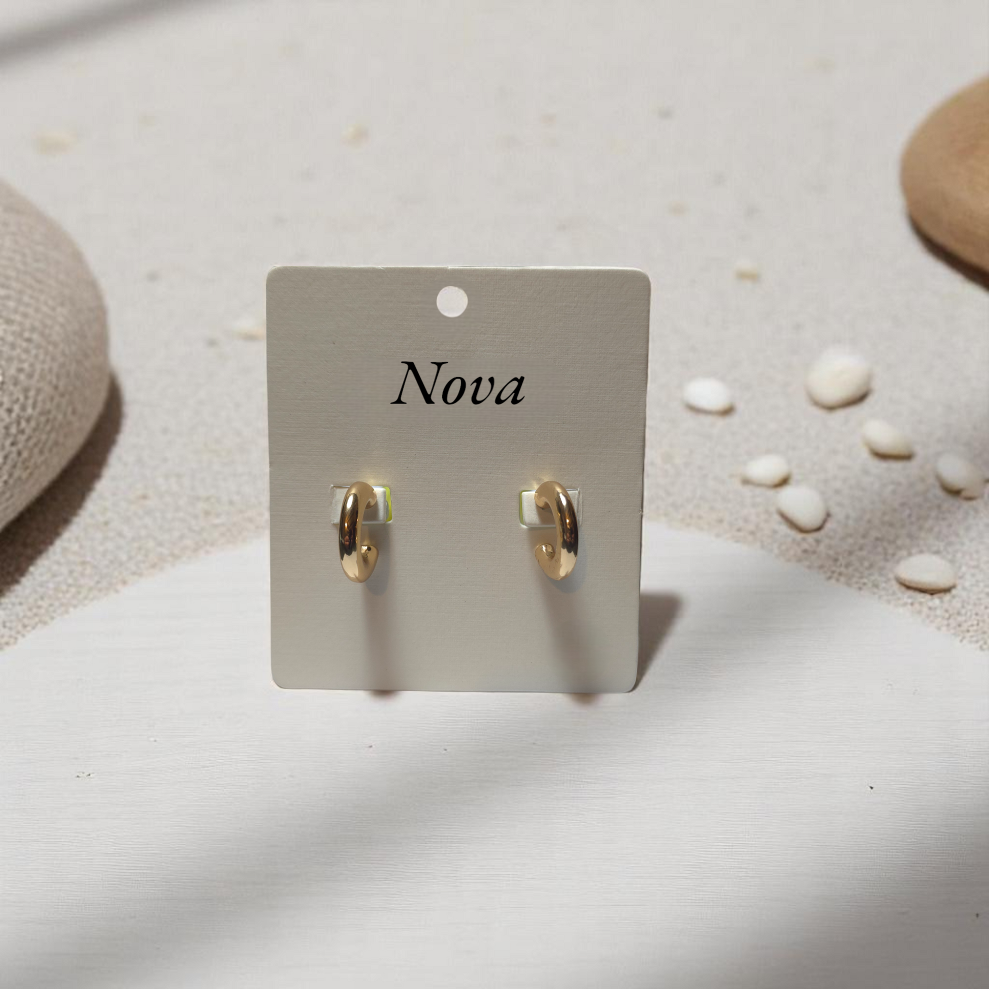 Detalle de aretes mini en dorado brillante con textura pulida